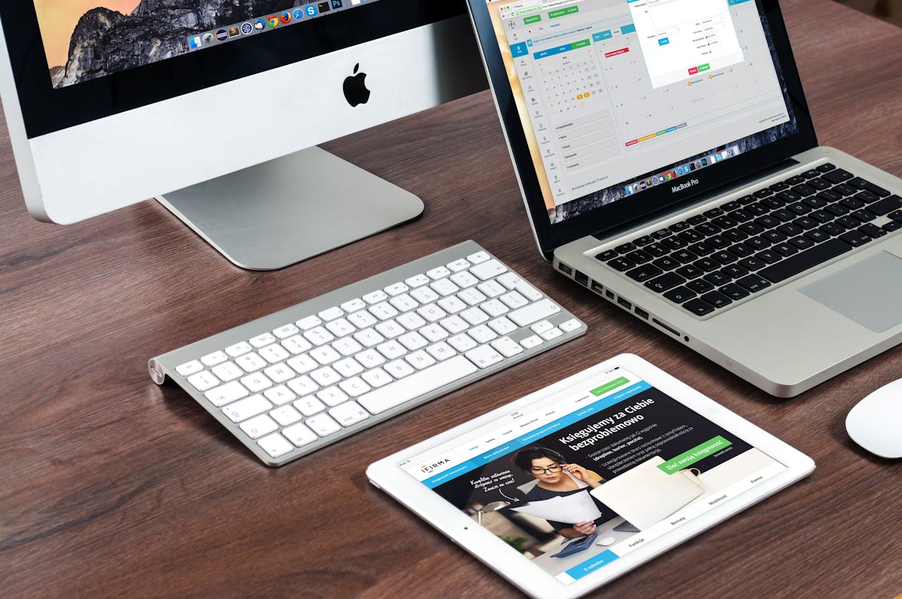 our-services-1 A sleek office desk setup featuring Apple devices: iMac, MacBook, and iPad.